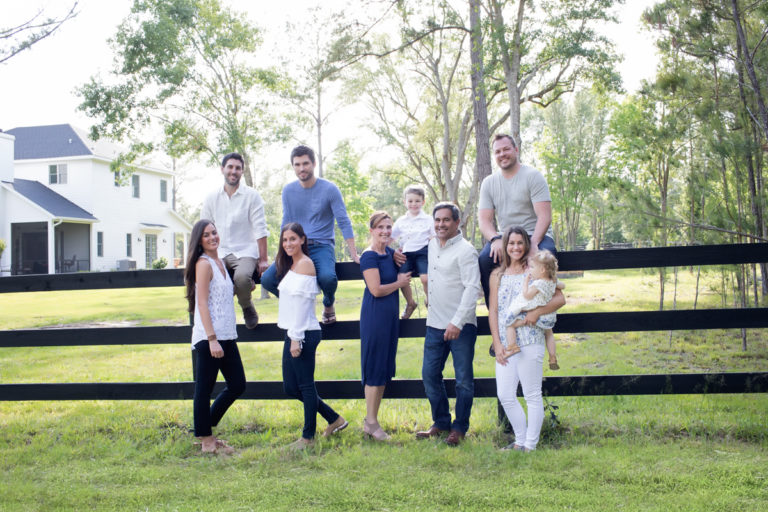 Three generations family with grandchildren posed at fence in light filled outside photo Williston Florida