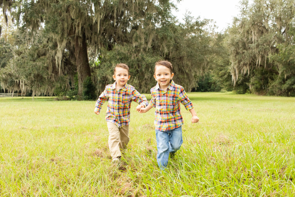 Family Photos Three Year Old Twin Boys hand in hand running through field at Horseshoe Farm Alachua Florida