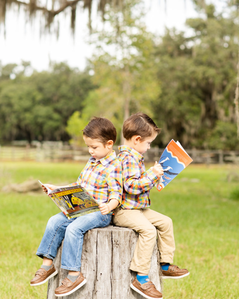 Family Photos Three Year Old Twin Boys reading books on tree stump at Horseshoe Farm Alachua Florida