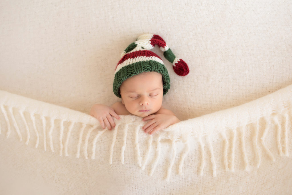 newborn portrait baby boy Nathan all tucked in with cream woven blanket and Christmas sleepy hat Gainesville FL newborn photography
