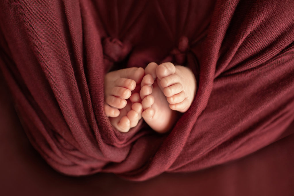 Newborn twin girls photos Janae and Renae feet in burgundy wrap
