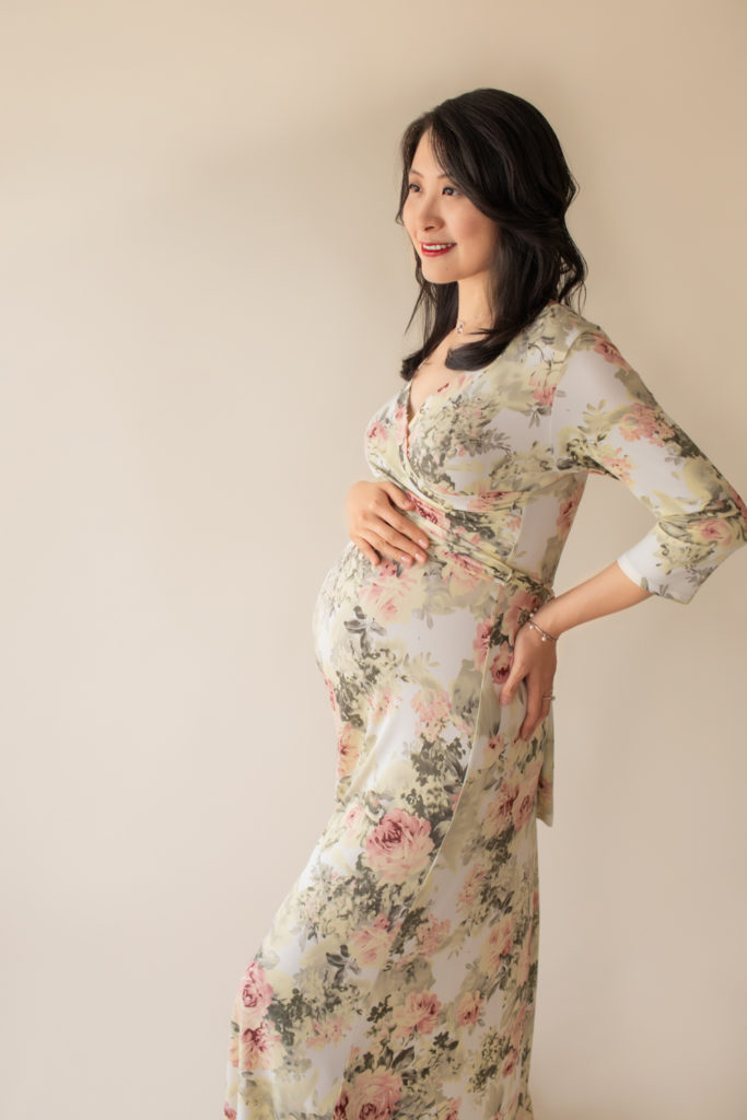 Maternity photos mom wearing floral pink and sage maternity gown in an ivory jersey fabric profile shot smiling looking sideways Gainesville Florida maternity photographer