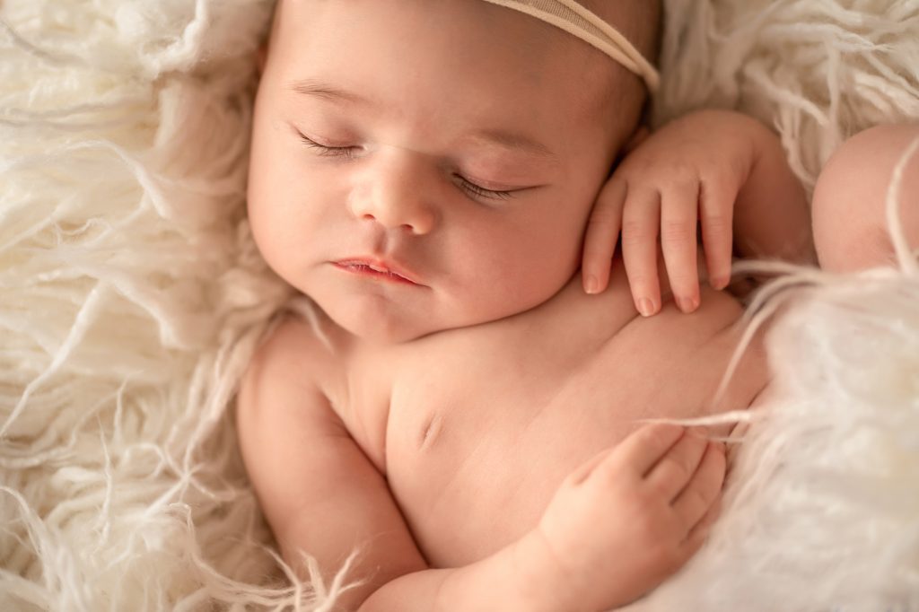 Gainesville Newborn moments close up newborn baby details eyelashes lips dainty chin tiny hands soft baby skin posed against white fur Gainesville Florida newborn photography