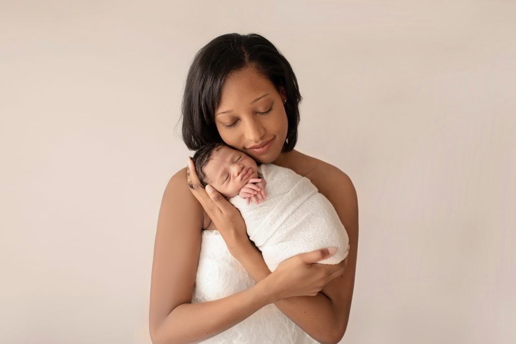 newborn photoshoot boy Christian bundled in cream knit blanket posed in arms of gorgeous mom wrapped in ivory lace cuddled together sleeping Gainesville Fl newborn picture