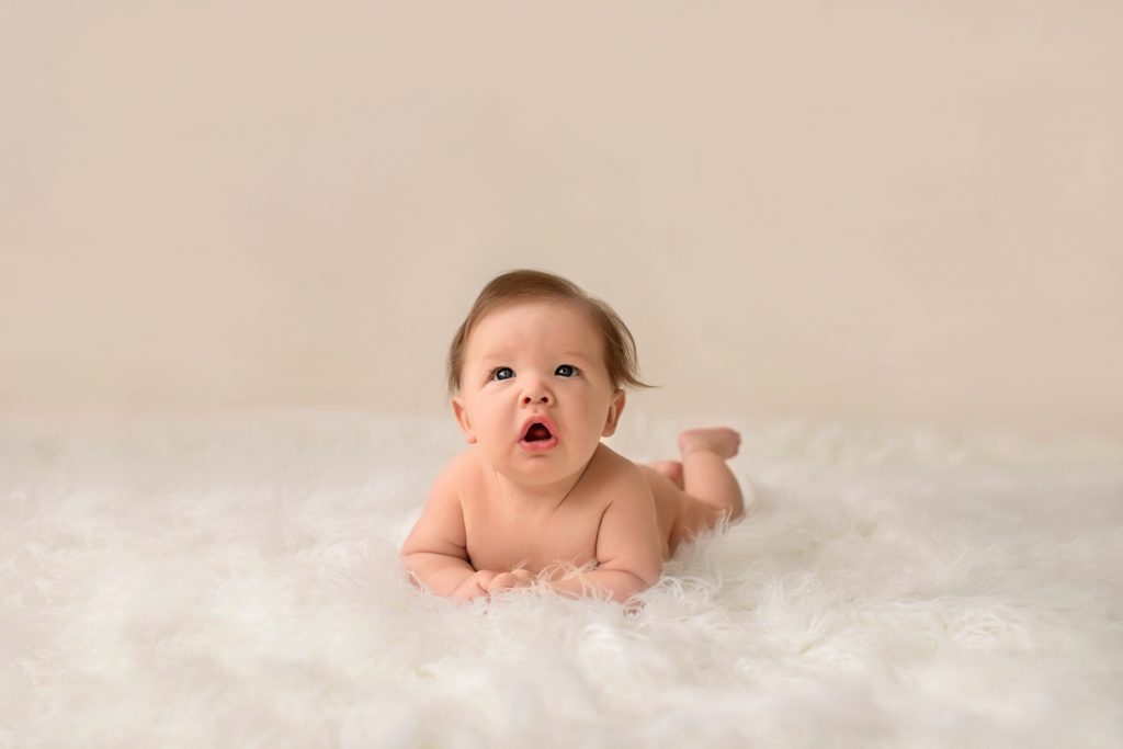 Garrett posed naked soft baby skin propped on elbows on soft white fur