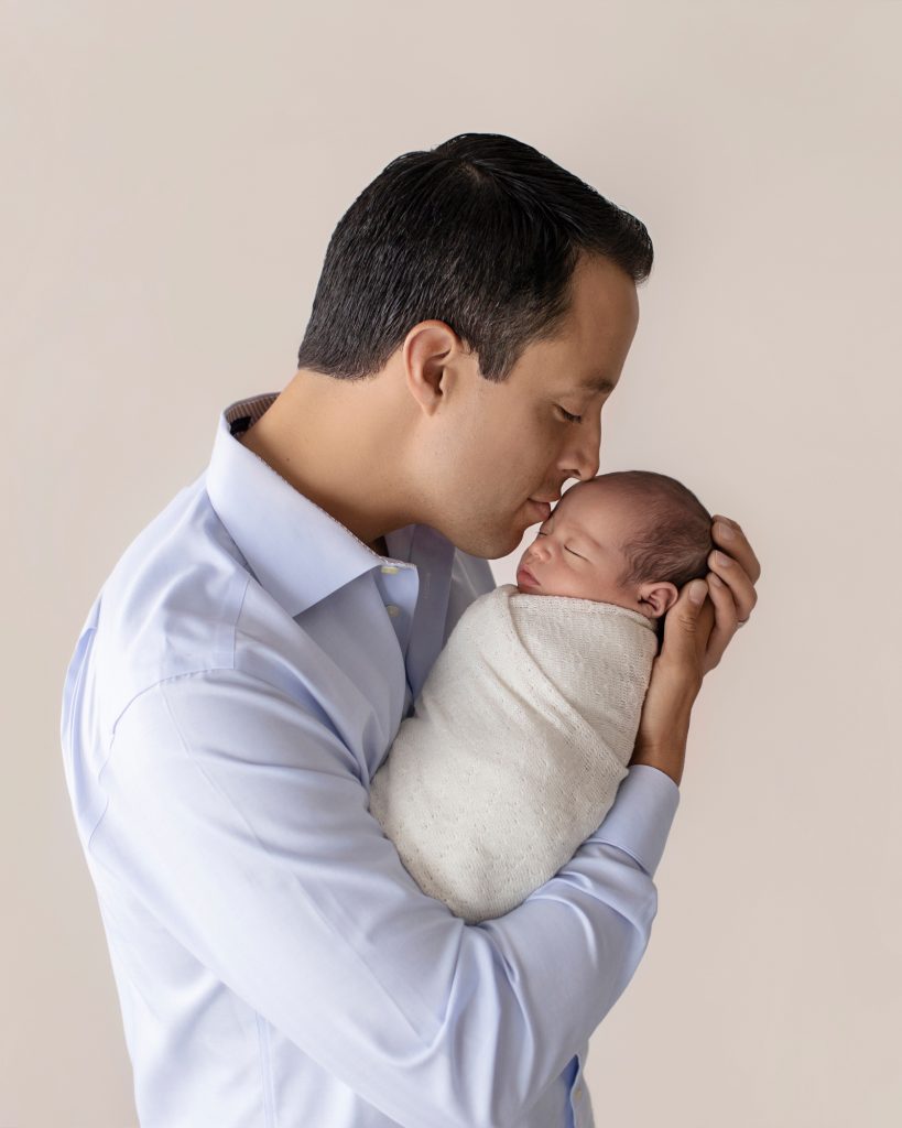 proud daddy gives his newborn baby special kiss emotion of new father