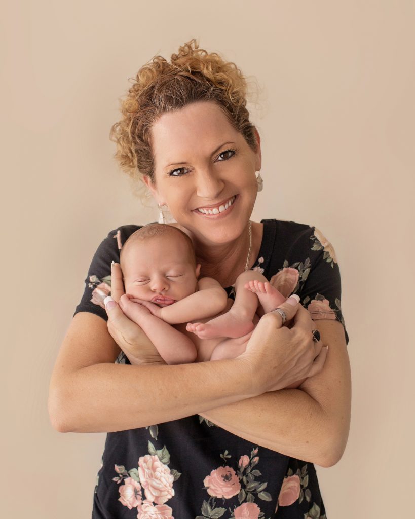 naked baby sleeping in the arms of very happy gorgeous grandma