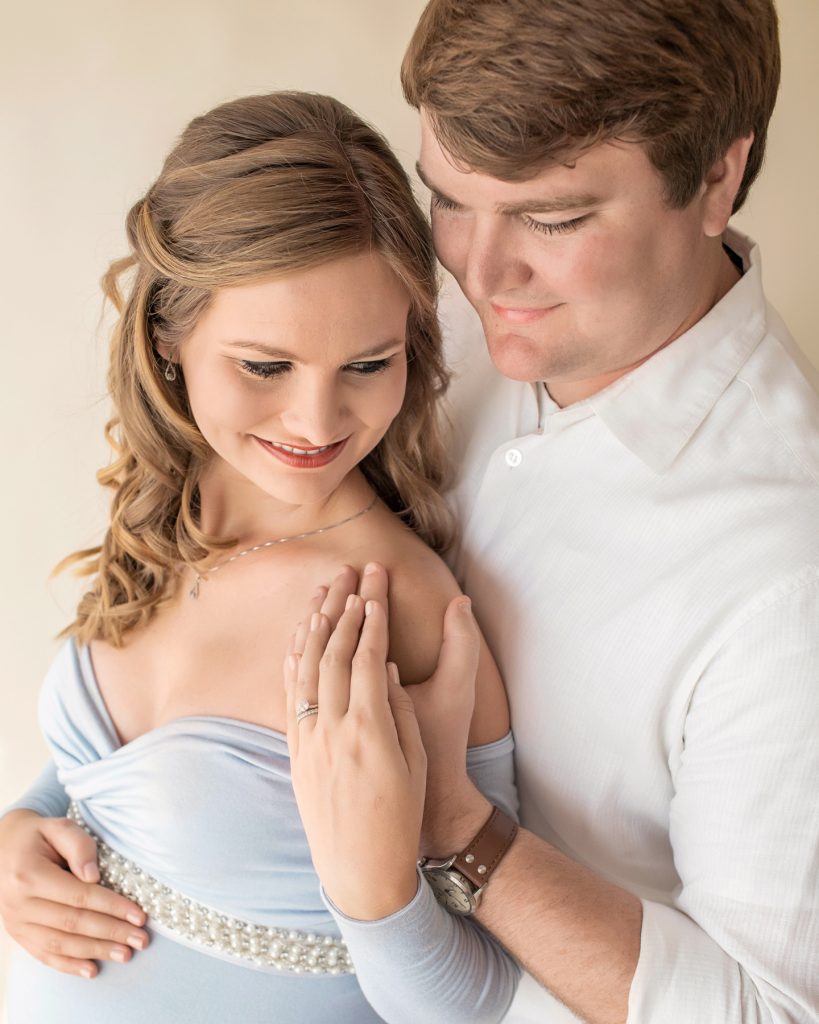 Gorgeous mom long blond curls in long sleeve baby blue maternity gown with handsome dad photo from above