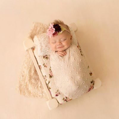 mini newborn photo session girl in ivory lace on floral bed floral headtie Gainesville FL