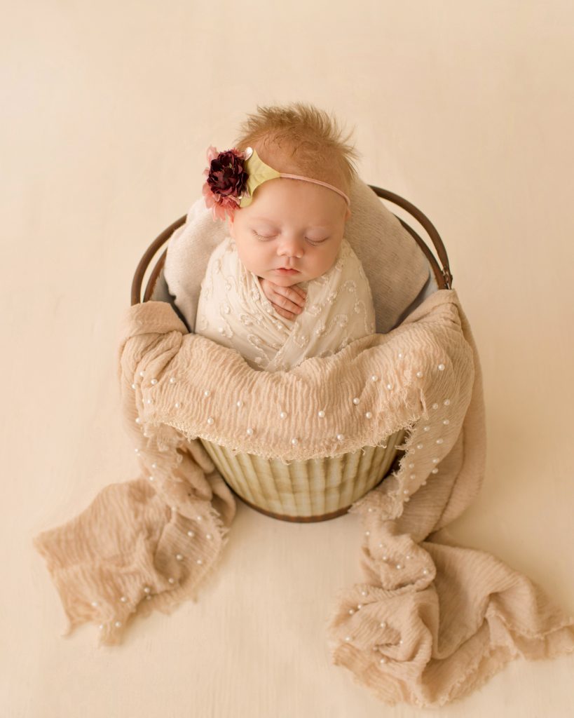 newborn girl baby in a bucket ivory lace in floral headtie Gainesville FL