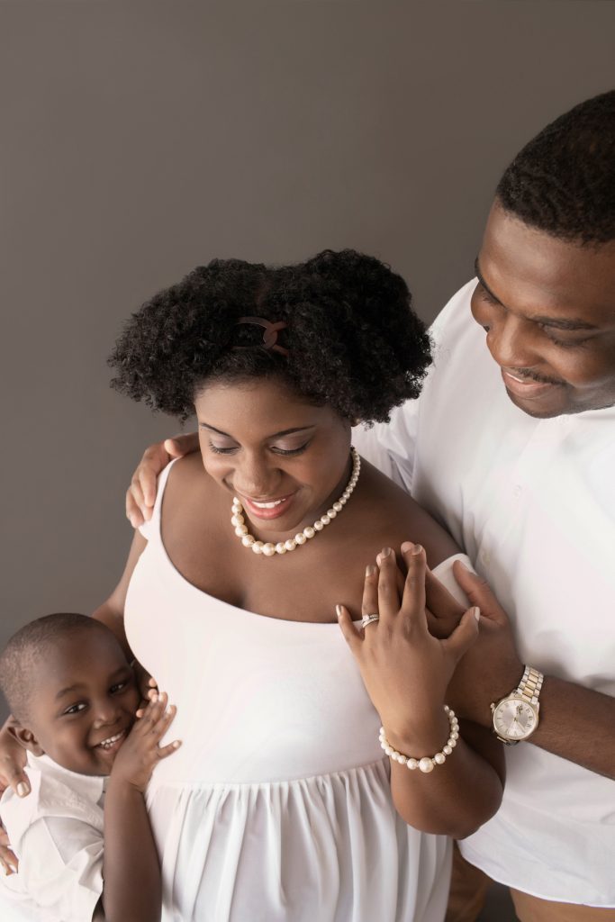 family maternity picture dad mom boy dressed in white boy hugging beautiful baby bump from above Gainesville FL