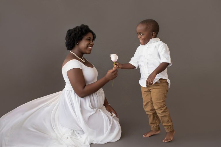 maternity portrait boy hands pink rose to mom for baby sister white chiffon maternity gown Gainesville FL