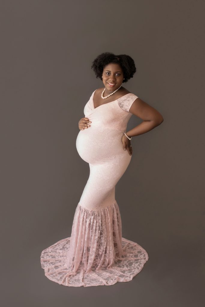 pale pink lace mermaid maternity gown decked in pearls pregnant mom profile smiles at camera