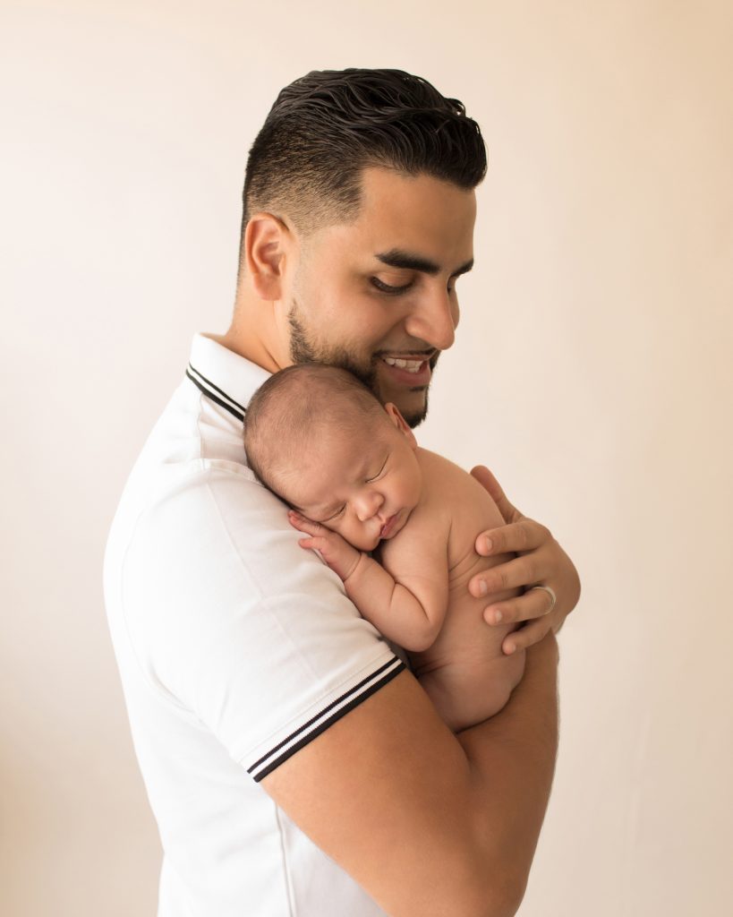 Proud dad holds naked newborn on his shoulder Gainesville FL