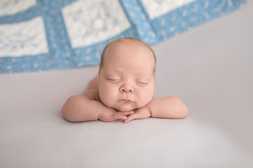 baby boy posed resting chin on hands facing camera Gainesville FL newborn photography