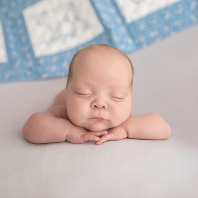 baby boy posed resting chin on hands facing camera Gainesville FL newborn photography