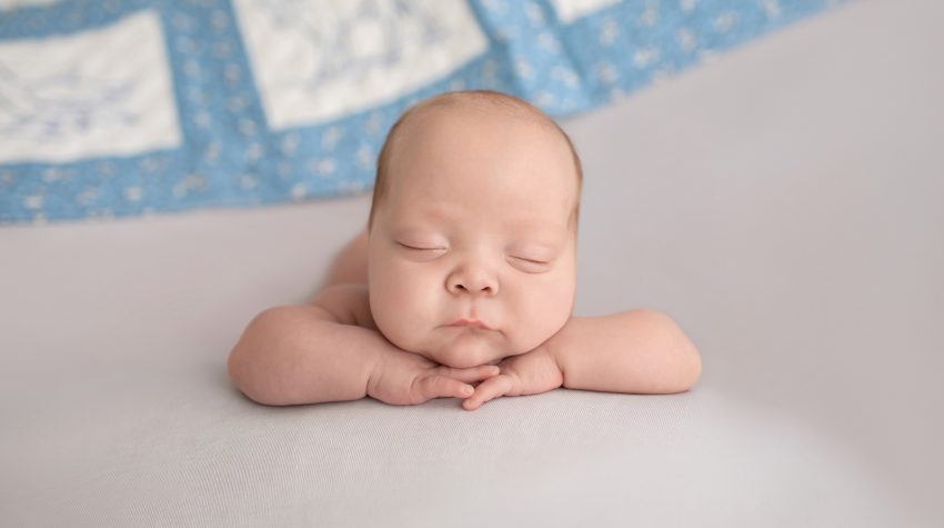 baby boy posed resting chin on hands facing camera Gainesville FL newborn photography